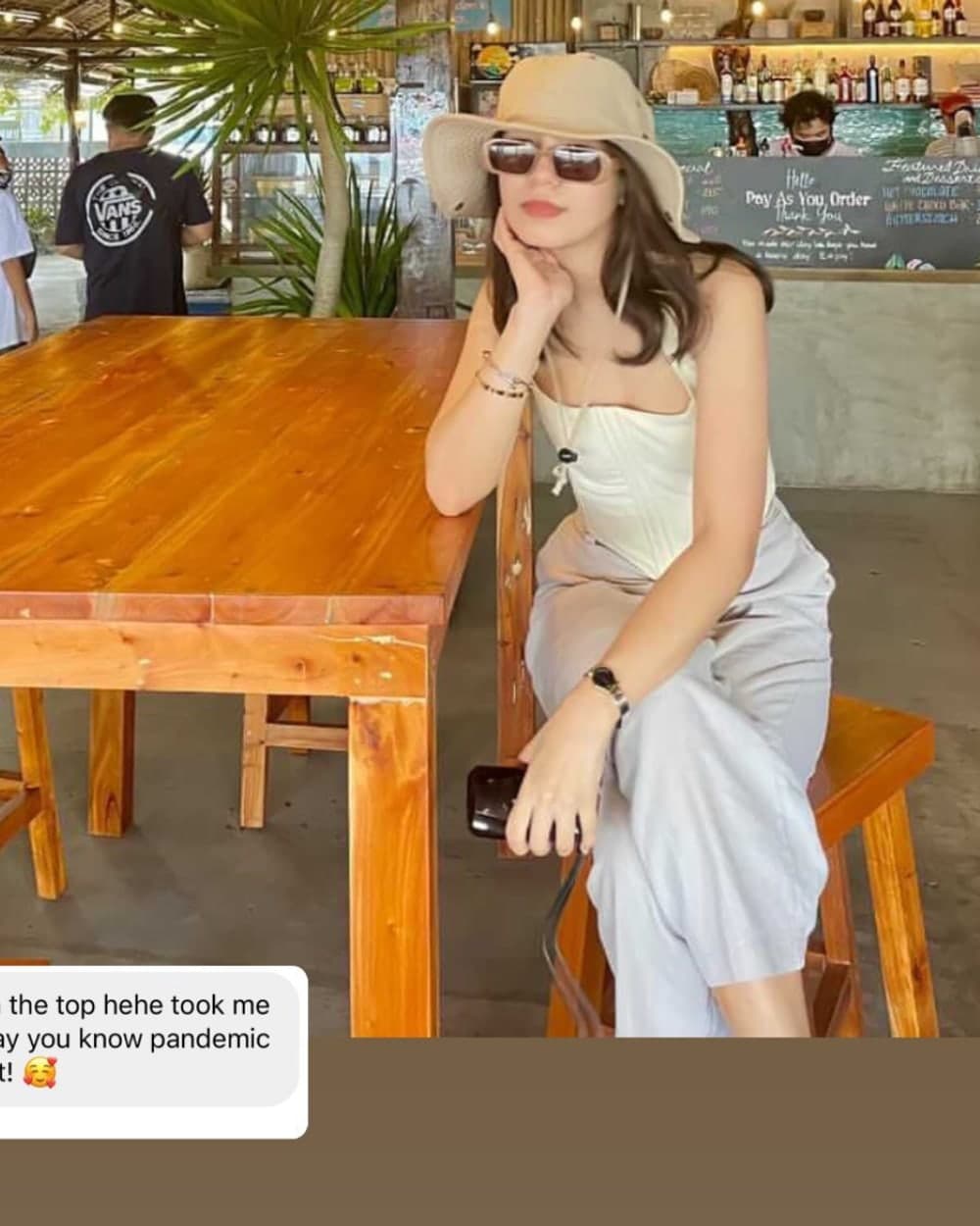 A customer wearing the doce linen corset top at an open-air cafe